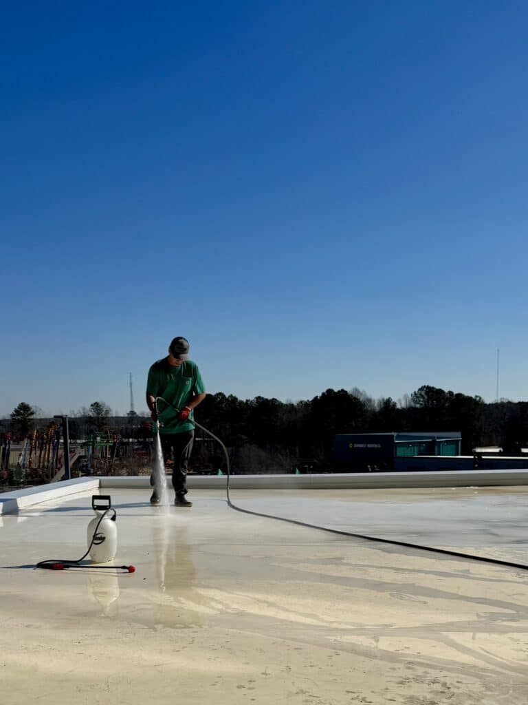 A team member from Bean’s Power Clean performs post-construction roof cleaning, ensuring the surface is pristine without damaging the new roofing material.